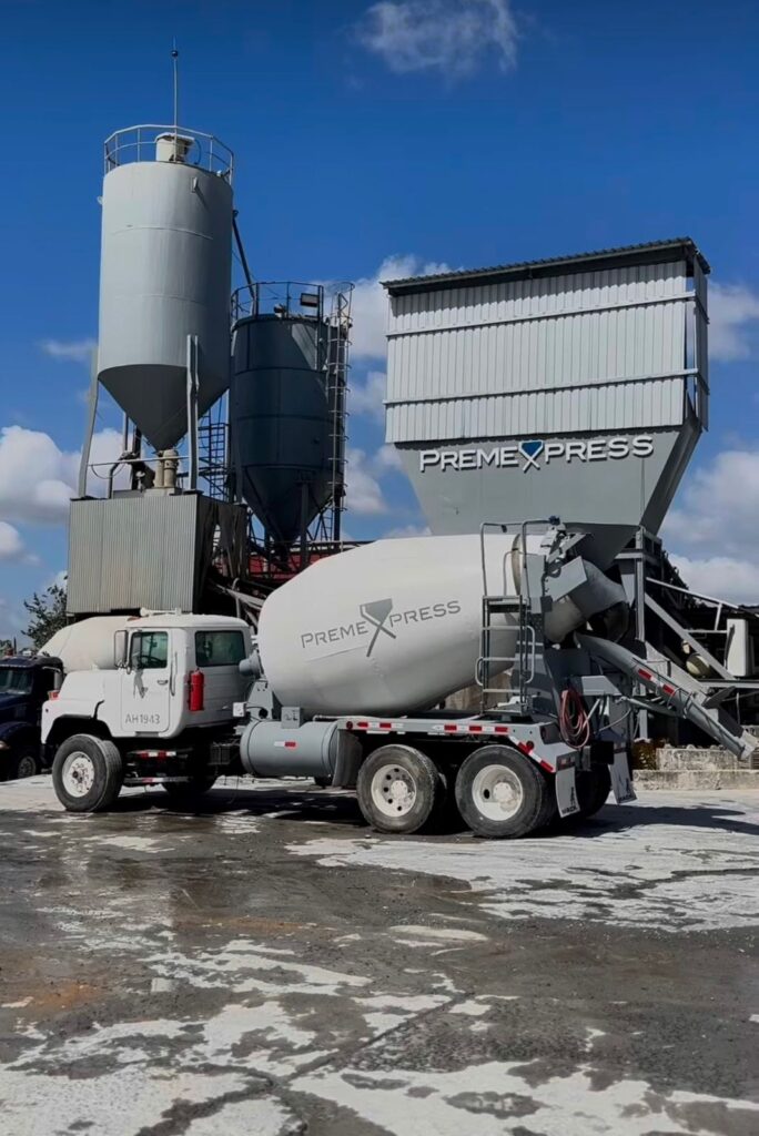 Camión mezclador de concreto de PremeXpress junto a la planta de concreto premezclado con silos en Panamá
